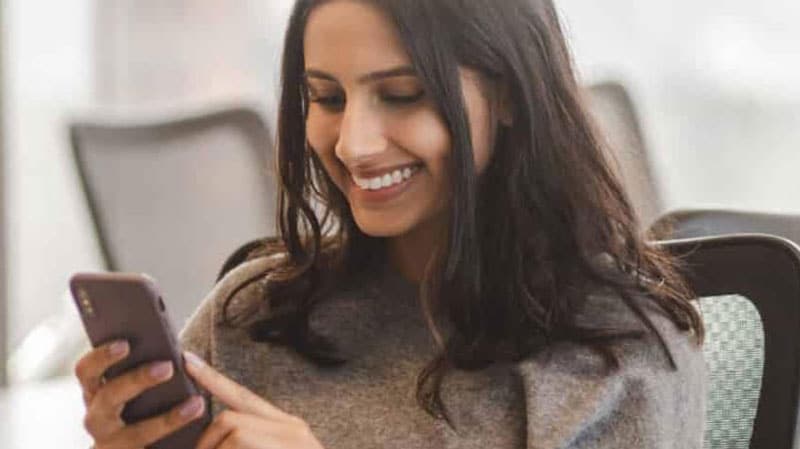mobile device in smiling womans hand