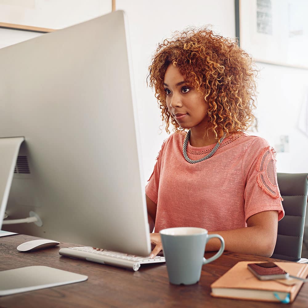 woman typing on computer with coffee woman typing on computer with coffee