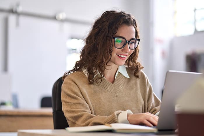Woman working on laptop smiling