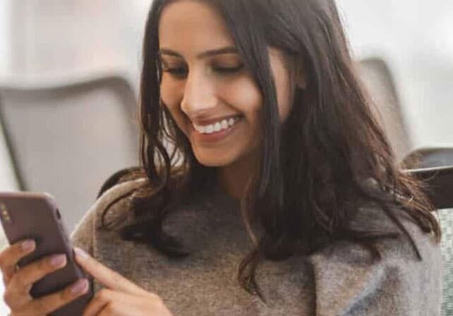 mobile device in smiling womans hand