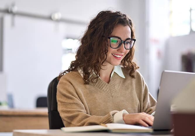 Woman working on laptop smiling